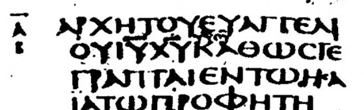 Black-and-white photograph of the opening lines of Mark in Greek capitals, with tiny letters written above the second line.